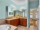 Bathroom with dual sinks, wood cabinets with granite countertop, and access to Primary bedroom at 34714 Heavenly Ln, Dade City, FL 33525