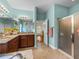 Bathroom featuring wood cabinets, granite countertop, separate shower, and access to bedroom at 34714 Heavenly Ln, Dade City, FL 33525