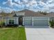 Inviting home exterior with a well-manicured lawn, a spacious driveway, and a charming facade at 34714 Heavenly Ln, Dade City, FL 33525
