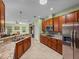 Open kitchen boasts wood cabinets, stainless steel appliances, granite countertops, and tile flooring at 34714 Heavenly Ln, Dade City, FL 33525