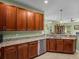 Kitchen featuring wood cabinetry, stainless appliances, and granite countertops in an open layout at 34714 Heavenly Ln, Dade City, FL 33525