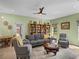 Living room is brightly lit with a bookshelf, comfortable seating, and an adjacent dining area at 34714 Heavenly Ln, Dade City, FL 33525