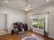 Bright office space with hardwood floors, ceiling fan, and large window offering neighborhood views at 34714 Heavenly Ln, Dade City, FL 33525