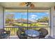 View of a screened-in balcony with seating, overlooking green space at 387 S Mcmullen Booth Rd # 16, Clearwater, FL 33759