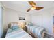 This bedroom is furnished with twin beds and a ceiling fan at 387 S Mcmullen Booth Rd # 16, Clearwater, FL 33759
