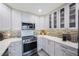Well-lit kitchen featuring stainless steel appliances, white cabinets, and a stylish backsplash at 387 S Mcmullen Booth Rd # 16, Clearwater, FL 33759