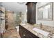 Bathroom with granite countertops, dark wood cabinets and drawers, dual sinks, and a tiled glass shower at 39650 Us Highway 19 N # 1422, Tarpon Springs, FL 34689