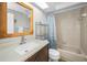 Bathroom with a combined shower and tub with blue patterned curtains and a vanity with a dark wood cabinet at 39650 Us Highway 19 N # 1422, Tarpon Springs, FL 34689