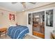 Bedroom boasting a blue striped bedspread and sliding glass doors leading to the rest of the house at 39650 Us Highway 19 N # 1422, Tarpon Springs, FL 34689