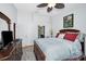 Bedroom with a ceiling fan and an ensuite bath with double doors and a king size bed at 39650 Us Highway 19 N # 1422, Tarpon Springs, FL 34689