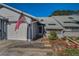 Charming townhouse with attached garage featuring well-maintained landscaping and an American flag near the front entrance at 39650 Us Highway 19 N # 1422, Tarpon Springs, FL 34689