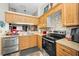 Well-equipped kitchen featuring light wood cabinets, stainless steel appliances, and mosaic tile backsplash at 39650 Us Highway 19 N # 1422, Tarpon Springs, FL 34689