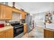 Well-lit kitchen featuring modern appliances, wood cabinets, and tile backsplash at 39650 Us Highway 19 N # 1422, Tarpon Springs, FL 34689