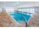 Large indoor pool with stairs, ladder, and a tiled patio at 39650 Us Highway 19 N # 1422, Tarpon Springs, FL 34689