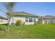 Manicured backyard featuring a lush green lawn, a glimpse of the house, and blue sky above at 4032 Tour Trce, Land O Lakes, FL 34638
