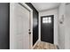 Welcoming home entrance featuring a black door, neutral-toned rug and white trim and walls at 4118 Ramona Dr, Spring Hill, FL 34606