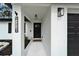 Charming home entrance with black door, stylish exterior lighting, house numbers and 'Let it Snow' door mat at 4118 Ramona Dr, Spring Hill, FL 34606