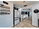 Bright open kitchen with stainless steel refrigerator, wood floors, and floating shelves at 4118 Ramona Dr, Spring Hill, FL 34606