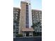 Exterior of condo featuring stone accents, balconies, and tropical landscaping near the entrance at 5400 Park N St # 200, St Petersburg, FL 33709