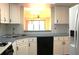 Functional kitchen with white cabinetry, solid surface counters, double sinks, and modern appliances at 5400 Park N St # 200, St Petersburg, FL 33709