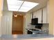 Bright kitchen features white cabinetry, modern appliances, tile backsplash, and a peek to living area at 5400 Park N St # 200, St Petersburg, FL 33709