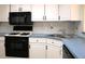 Kitchen featuring white cabinets, black appliances, and blue countertops at 5400 Park N St # 200, St Petersburg, FL 33709