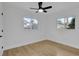 Bright bedroom features wood flooring, ceiling fan, and natural light from two windows at 5426 Creeping Hammock Dr, Sarasota, FL 34231
