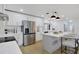 Modern kitchen featuring stainless steel appliances, white cabinetry and an island with pendant lighting at 5426 Creeping Hammock Dr, Sarasota, FL 34231