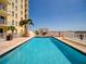 Rooftop swimming pool with clear blue water, palm trees, and lounging areas at 628 Cleveland St # 1507, Clearwater, FL 33755