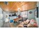 Inviting living area with wood-paneled ceiling, comfortable seating, and a bright dining space at 7501 Hollowell Dr, Tampa, FL 33615