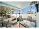 Screened patio featuring three chairs, a table, and a view of the fenced yard, ideal for outdoor relaxation at 7501 Hollowell Dr, Tampa, FL 33615