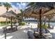 Outdoor grilling area with tiki umbrellas and picnic tables by the water at 7560 Bay Island S Dr # 144, South Pasadena, FL 33707