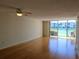 Spacious living room with laminate flooring, ceiling fan, and sliding glass doors with lake views at 7560 Bay Island S Dr # 144, South Pasadena, FL 33707