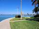 Scenic waterfront view featuring an American flag, picnic table and manicured lawn on a bright day at 7560 Bay Island S Dr # 144, South Pasadena, FL 33707