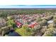 Overhead view of the residential community boasting red-roofed condos nestled amongst green trees and a serene lake at 9481 Highland Oak Dr # 1410, Tampa, FL 33647