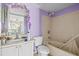 Bathroom with tiled shower and lavender accents at 9481 Highland Oak Dr # 1410, Tampa, FL 33647