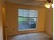 Cozy bedroom featuring a window with backyard view and neutral walls for easy customization at 9481 Highland Oak Dr # 1410, Tampa, FL 33647