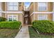 Exterior view of the building showcasing well-maintained shrubbery and a shared stairwell entry for residents at 9481 Highland Oak Dr # 1410, Tampa, FL 33647