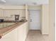Functional kitchen with neutral cabinets, laminate countertop, and tiled floor leading to entry at 9481 Highland Oak Dr # 1410, Tampa, FL 33647