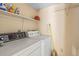 Functional laundry area with washer, dryer, and overhead storage shelves at 9481 Highland Oak Dr # 1410, Tampa, FL 33647