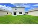 Well-maintained backyard with string lights, sliding doors, and lush green grass, perfect for entertaining or relaxing at 10908 Carlton Fields Dr, Riverview, FL 33579