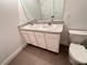 Well-lit bathroom showcases a double vanity, a large mirror, and a toilet, all set against neutral walls at 10908 Carlton Fields Dr, Riverview, FL 33579