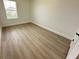 Bedroom featuring a window providing natural light, complemented by light wood flooring for a modern look at 10908 Carlton Fields Dr, Riverview, FL 33579