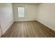 Empty bedroom space showcasing wood-look flooring and natural light at 10908 Carlton Fields Dr, Riverview, FL 33579