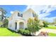 Charming two-story home with neutral stucco, dark shutters, arched entry, and mature landscaping at 10908 Carlton Fields Dr, Riverview, FL 33579