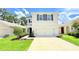 Charming two-story home with neutral stucco, dark shutters, two car garage, and well-manicured landscaping at 10908 Carlton Fields Dr, Riverview, FL 33579