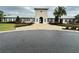 Community center exterior showcasing a light-colored facade, covered entrance, and meticulous landscaping at 10908 Carlton Fields Dr, Riverview, FL 33579