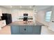 Modern kitchen features a large island with granite countertops, stainless steel sink and black appliances at 10908 Carlton Fields Dr, Riverview, FL 33579