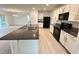 Bright kitchen with an island, featuring modern appliances, granite counters, and stylish light wood floors at 10908 Carlton Fields Dr, Riverview, FL 33579