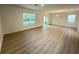 Spacious living room featuring wood-look flooring and natural light from large windows at 10908 Carlton Fields Dr, Riverview, FL 33579